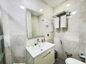 Un bany modern amb un rentapins blanc, un mirall i una barra de tovalloles.