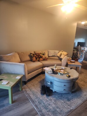 A living room with a sectional sofa, a coffee table, and a small side table. - Cozy 2-bedroom condo in beautiful Surfside Beach with AC (Surfside Beach)