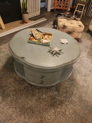 A round table with a box of items on top, a decorative object, and a patterned rug. - Cozy 2-bedroom condo in beautiful Surfside Beach with AC (Surfside Beach)