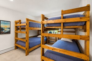 Bunk beds with blue bedding in a room with a Michigan state poster on the wall.