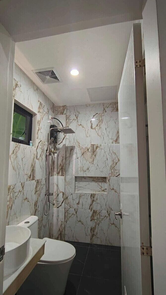 A bathroom with a shower, toilet, and sink.
