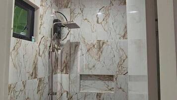 A bathroom with a shower, toilet, and sink.
