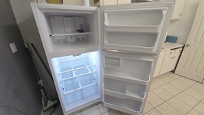 An open refrigerator with multiple shelves and a freezer compartment.