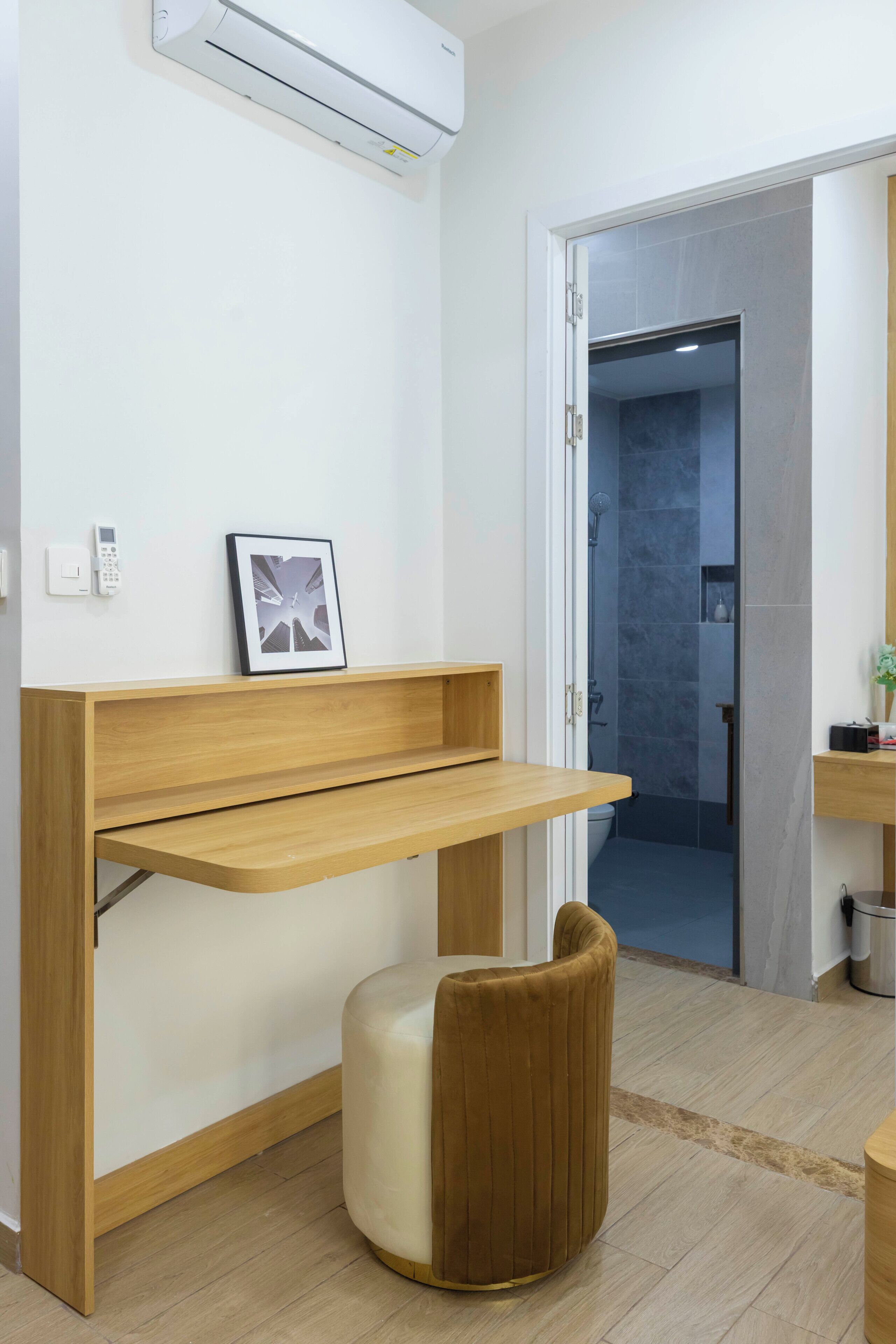 A modern bathroom with a wooden vanity, a toilet, and a shower area.