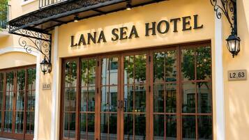 The exterior of Lana Sea Hotel with large glass doors and a balcony.