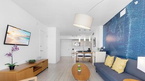 A modern living room with a sofa, coffee table, and a TV on the wall. - Modern Upscale 1BR, Bay & Marina View, Resort Pool (Hallandale Beach)