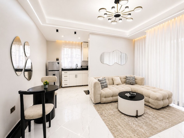 Un salon moderne avec un canapé, une table basse et un coin repas avec des chaises.