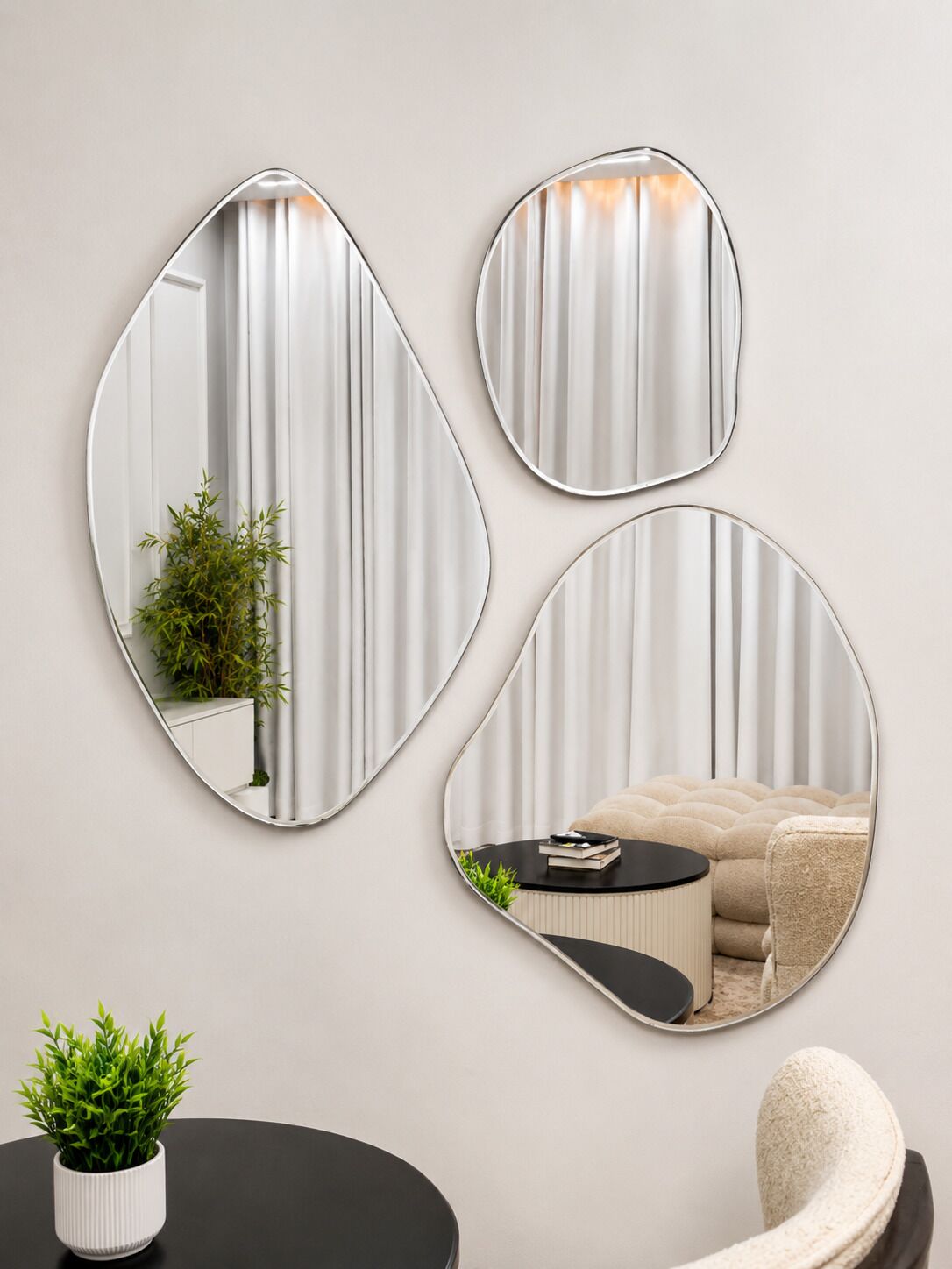 Three wall-mounted mirrors of varying shapes.