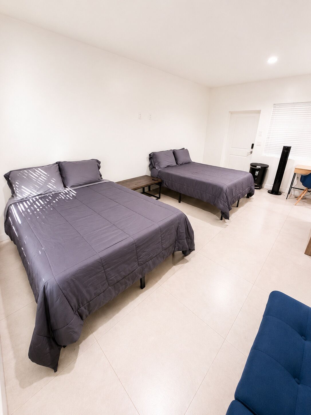 Une chambre avec deux lits, un bureau et une chaise.