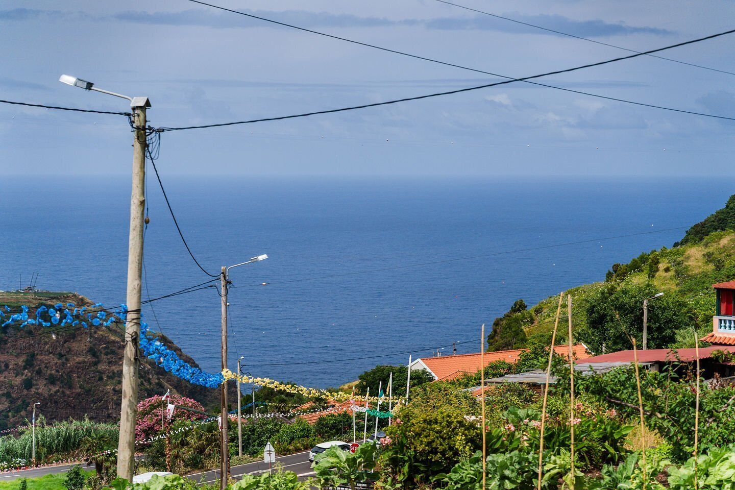 A coastal landscape with a road, vegetation, and a view of the sea.