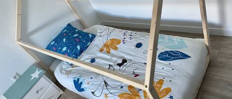 Un lit superposé avec une structure en bois et une couverture colorée.