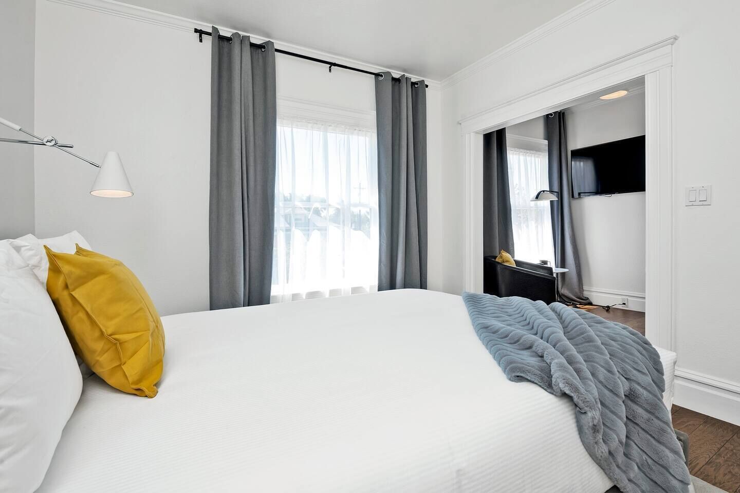 Een hotelkamer met een bed, een raam met gordijnen, een bedlampje en uitzicht.