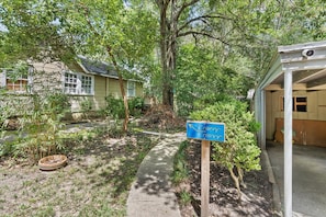 A pathway leading to a building with a sign indicating a college cottage.