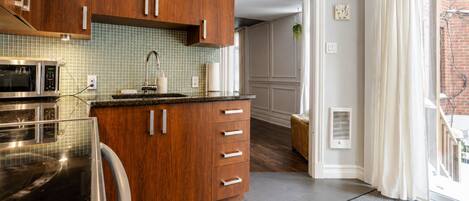 Une cuisine moderne avec des meubles en bois, un four à micro-ondes et un évier.