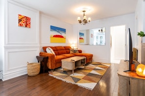 A living room with a sofa, a coffee table, a rug, a lamp, and artwork on the walls. - Bijou of the Plateau-Mont-Royal (Montréal)