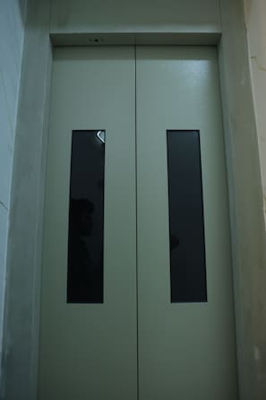 Puertas dobles con ventanas rectangulares, probablemente una puerta de ascensor o de servicio.