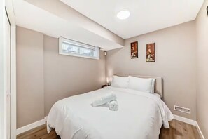 Habitación de hotel con cama, ventana y obras de arte en las paredes.