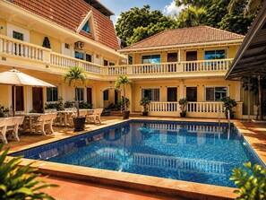 A two-story building with a swimming pool, outdoor seating, and a covered patio area.