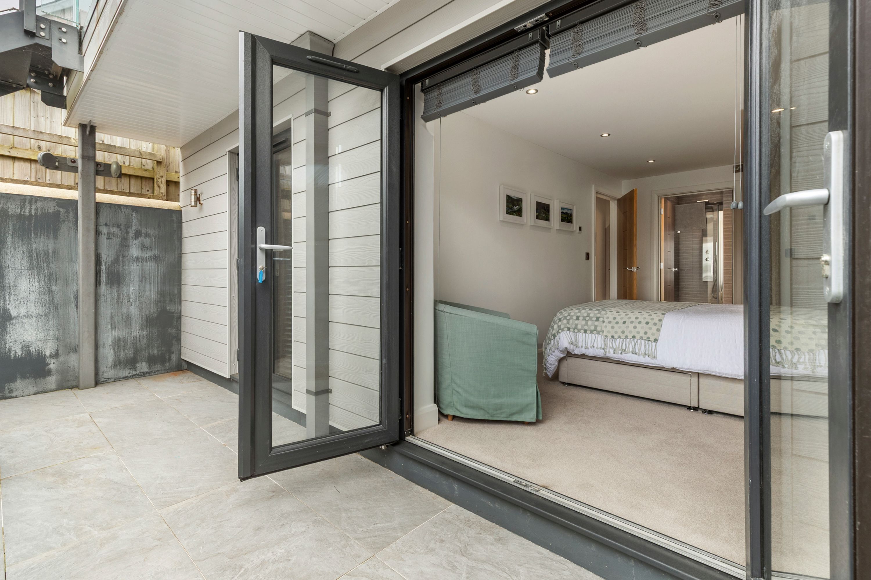 A modern bedroom with a sliding glass door leading to a bathroom.