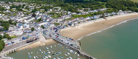 A coastal town with a marina, sandy beach, and residential buildings.