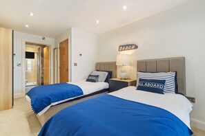 Ein Hotelzimmer mit zwei Betten, einem Badezimmer und einem Flur.