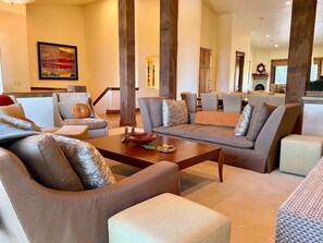 Ein geräumiges Wohnzimmer mit Couchtisch, mehreren Sofas und einem Kamin.