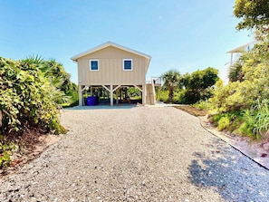 A two-story building with a gravel driveway leading to a covered entrance. - Wake up to ocean breezes! (St. Augustine)