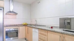 Una cocina equipada con horno empotrado, lavavajillas y microondas.