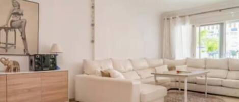 A modern living room with a white sofa, a coffee table, and a sideboard.