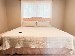 A single bed with a white quilt and a remote control on it. - The Storybook Stay / Woodson Historic District (Gallatin)