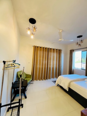 A hotel room with a bed, a chair, a wheelchair, a ceiling fan, and a window with curtains. - Palm Residence retreat in Paje (Paje)
