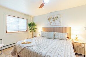 A bedroom with a bed, bedside tables, a world map on the wall, and a window with blinds. - Modern, pet-friendly Retreat near everything! (Montrose)