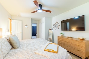 A bedroom with a bed, a dresser, a television, and a ceiling fan. - Modern, pet-friendly Retreat near everything! (Montrose)