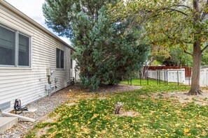 A residential property with a house, a fenced yard, and a large tree. - Modern, pet-friendly Retreat near everything! (Montrose)