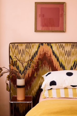 A bed with a yellow bedspread and a pillow with black spots, a vase with dried flowers, and a framed picture on the wall. - Retro Bronte Beach Pad | 4 Min Walk to Beach (Bronte)