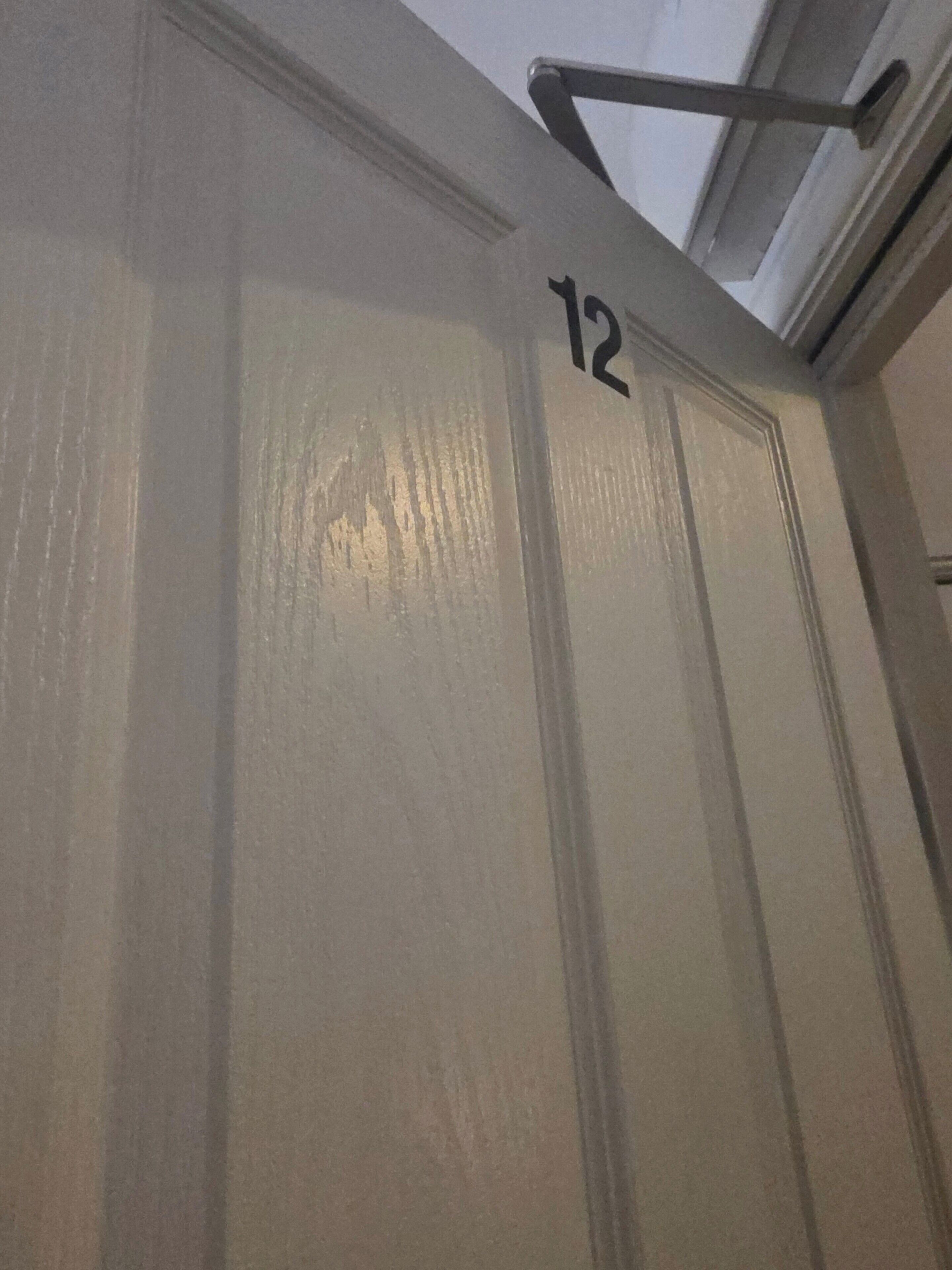 A door with the number 12 on it, a metal handle, and a window above.