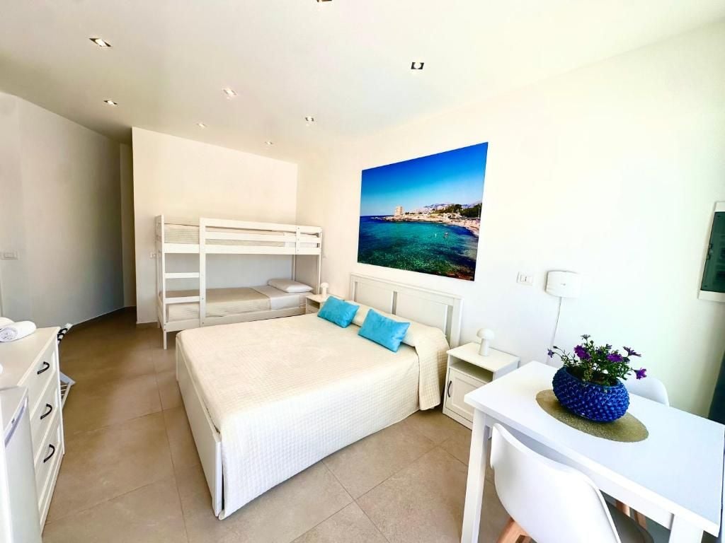 A bedroom with a bunk bed, a desk, and a chair.