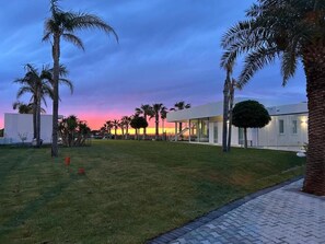 Un moderno complejo de edificios con un césped y palmeras.
