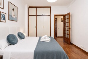 A bedroom with a bed, pillows, a wardrobe, and a door leading to another room. - TenoHomes YSLA Escape Buenavista (Buenavista del Norte)