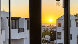 Sonnenuntergangblick von einem Balkon, im Hintergrund Gebäude.