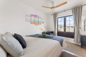 A hotel room with a bed, a desk, a window with curtains, and a ceiling fan. - Home2Book Golden Apt Pool & Terrace Costa Teguise (Costa Teguise)