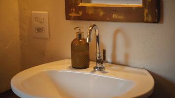 Un lavabo de salle de bain avec un seul robinet et un distributeur de savon.