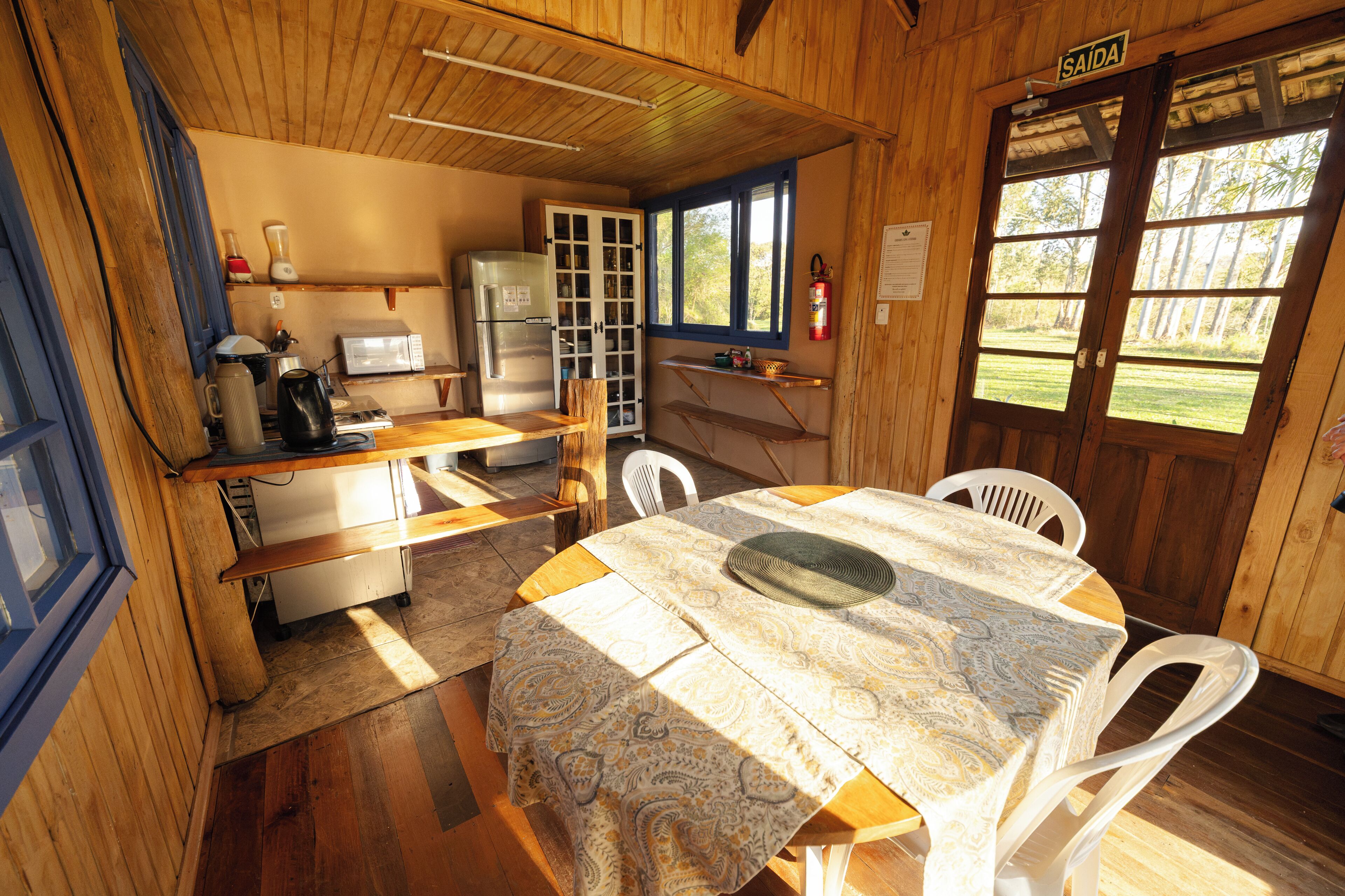 Una cucina compatta con frigorifero, forno a microonde e un pensile in legno.