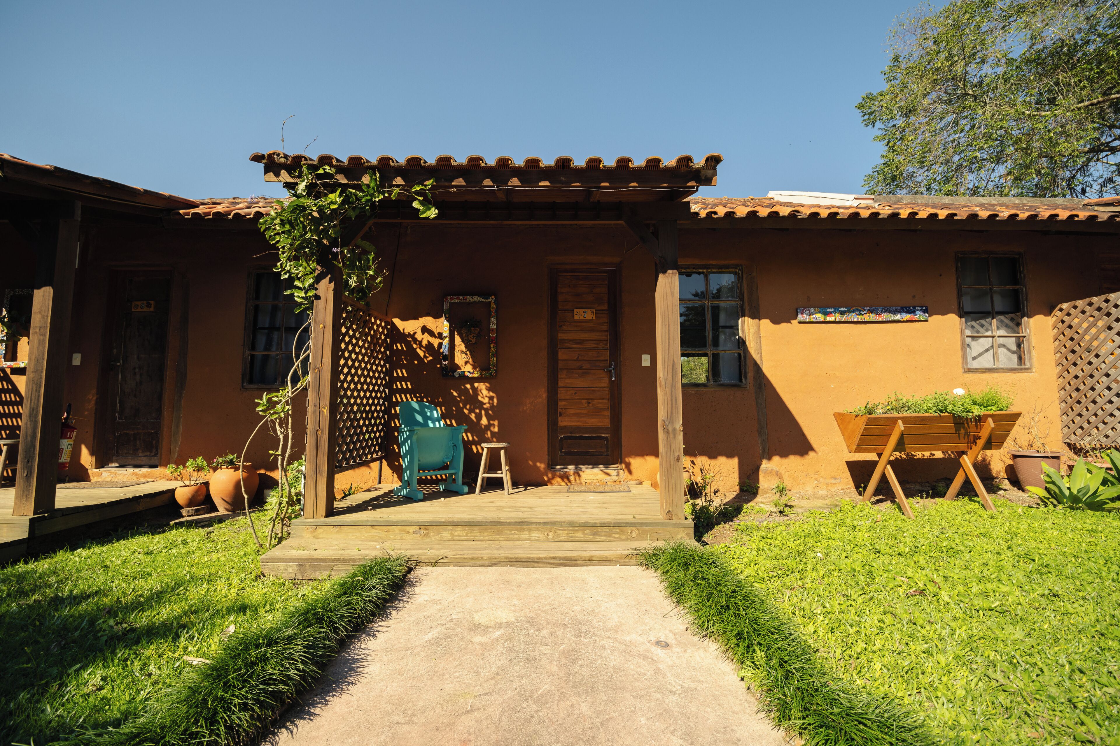 A rustic building with a wooden porch, a door, and a window.