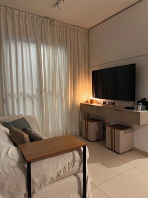 A modern living room with a flat-screen TV, a wooden coffee table, and a sofa. - New apartment in Porto, in the center of Rio de Janeiro. The ideal place to visit tourist attractions. (Rio de Janeiro)