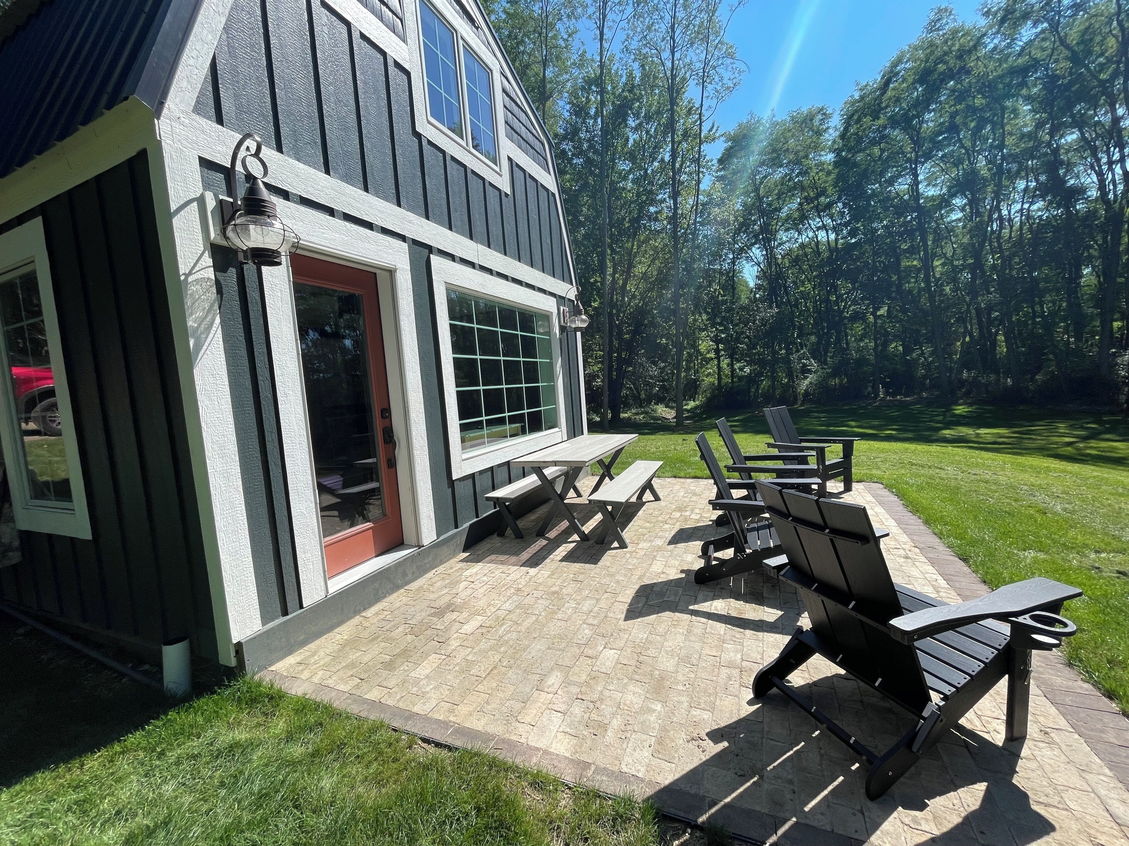 A patio with outdoor seating and a house with a red door.
