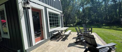 A patio with outdoor seating and a house with a red door.