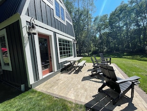 A patio with outdoor seating and a house with a red door.