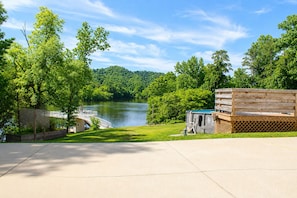 A lakeside property with a wooden deck, a small building, and a view of a lake surrounded by trees. - Lakefront 3 Story Cape Cod 4 bed 3.5 bath 2 private docks, boat ramp and pool (Harriman)