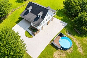A two-story house with a swimming pool, surrounded by a well-maintained lawn and trees. - Lakefront 3 Story Cape Cod 4 bed 3.5 bath 2 private docks, boat ramp and pool (Harriman)